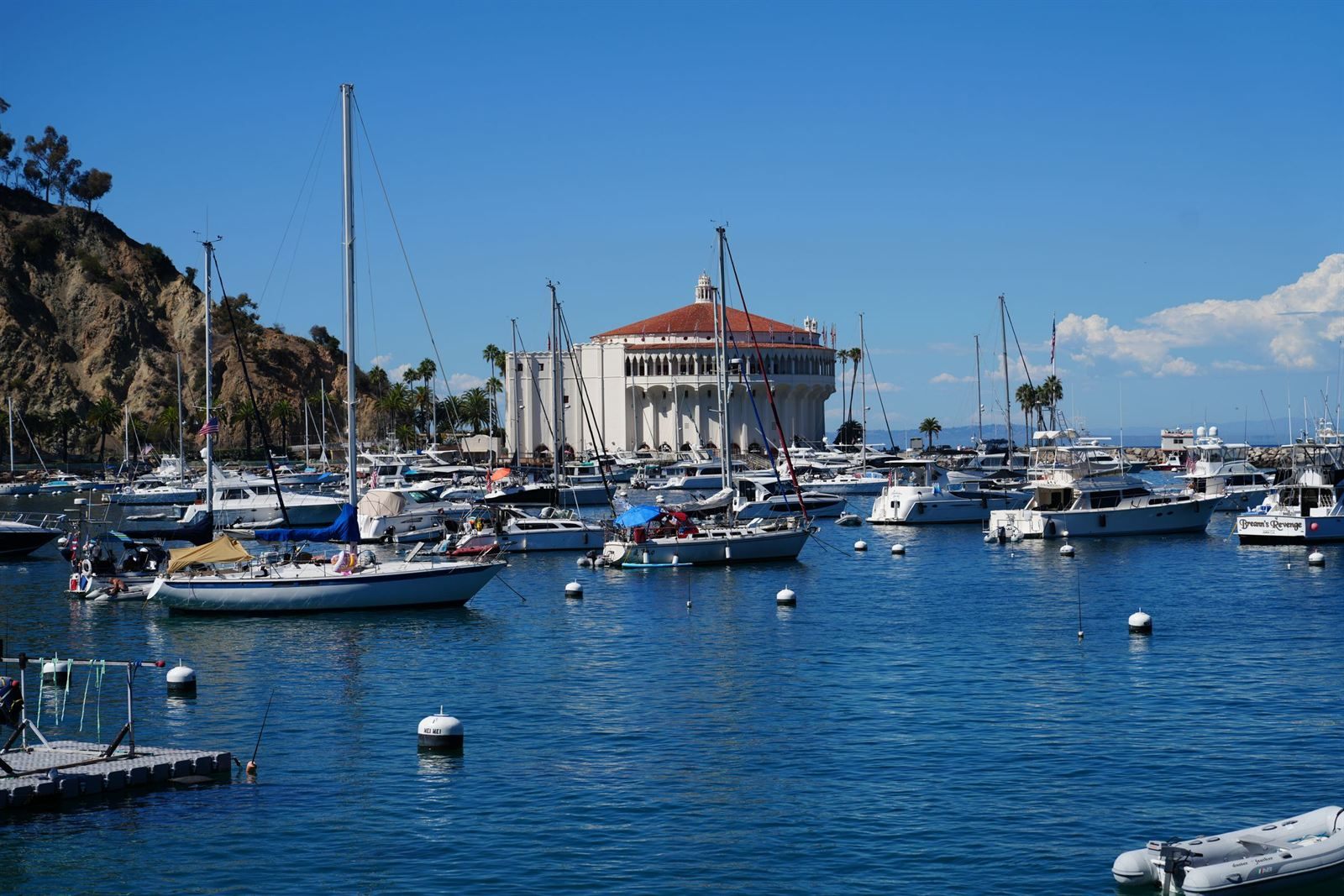 Sailboats moored in Avalon Harbor on Catalina Island in front of the round Casino building